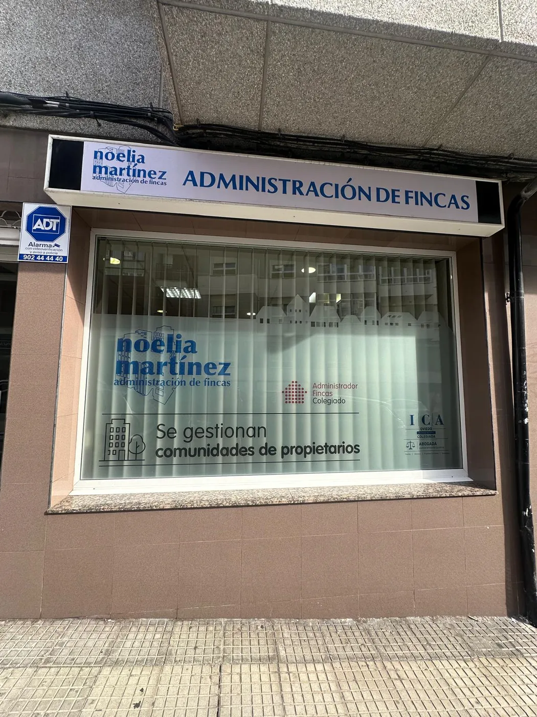 Oficina de Noelia Martínez en Pravia: rótulo de administración de fincas y escaparate con el logo